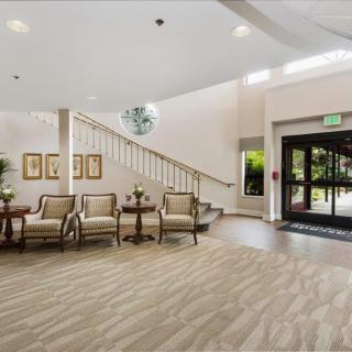 A bright and spacious lobby with elegant seating and a staircase leading upstairs.