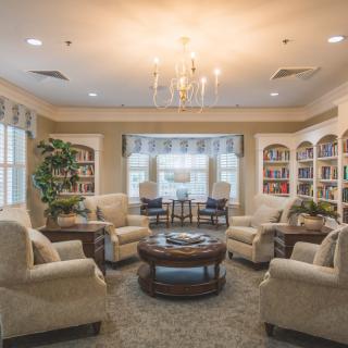 A cozy and elegant living room with comfortable seating and a chandelier.