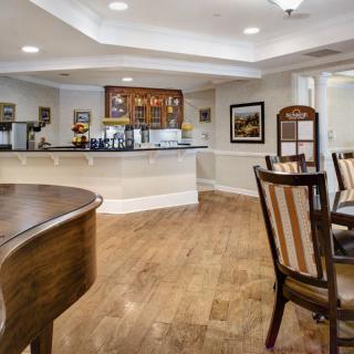 A cozy lobby area with wooden flooring and comfortable seating around a counter.