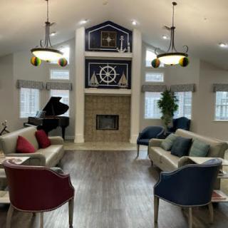 A cozy modern lounge featuring a fireplace, seating areas, and a piano.