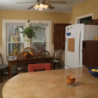 A cozy kitchen with a dining table, chairs, and a plant near the window.