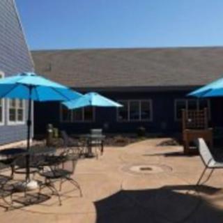 A sunny patio with blue umbrellas and seating arrangements.