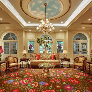 A luxurious hotel lobby with elegant furnishings and a decorative chandelier.
