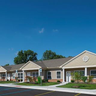 A row of suburban residential homes under a clear blue sky.