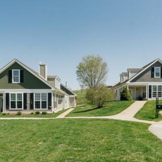 Two suburban houses with driveways and a well-maintained lawn.
