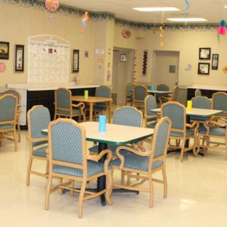 An empty dining room with several tables and chairs arranged neatly.