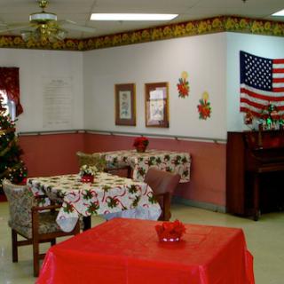 A cozy dining area decorated for the holidays, featuring a Christmas tree and an American flag.