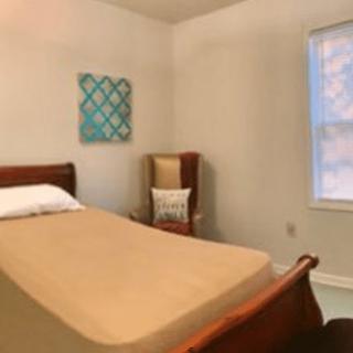 A minimalist bedroom with a single bed and window.