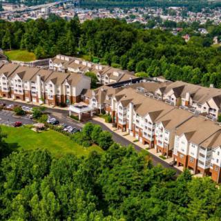 An aerial view of a residential housing complex surrounded by lush greenery.