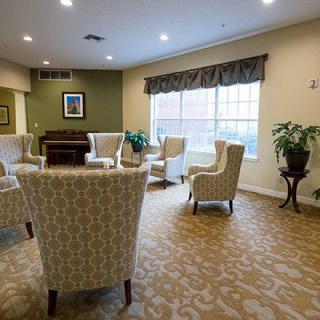 A cozy communal living room with comfortable seating and large windows.