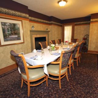 A formal dining room with a table set for guests.