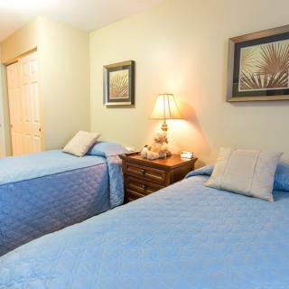 A cozy bedroom with two twin beds and soft lighting.