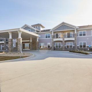 A modern residential building with a driveway in front.