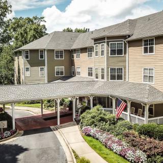 A residential building with a landscaped entrance and an American flag.