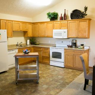 A modern kitchen with wooden cabinets, complete with appliances and decorative items.