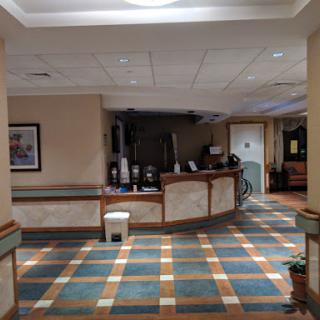 A spacious lobby area featuring a reception desk and colorful tiled flooring.