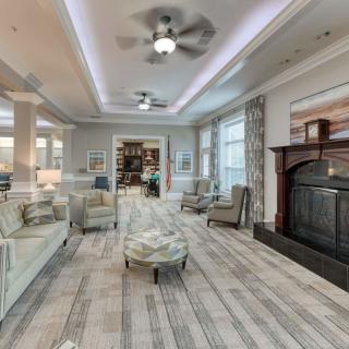 A spacious and elegantly designed living room featuring a fireplace, comfortable seating, and ample natural light.