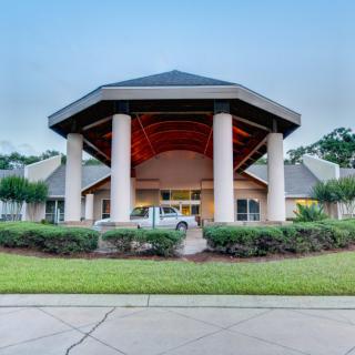 A grand building entrance with large columns and a circular driveway.