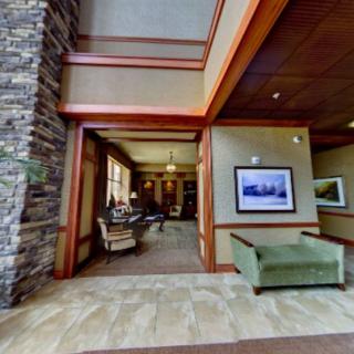 A spacious lobby area featuring a stone wall, comfortable seating, and artwork on the walls.