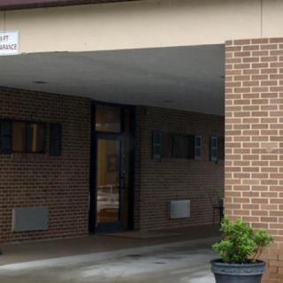 Entrance of a building with brick walls and a potted plant.