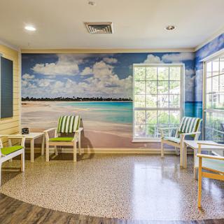 A serene waiting area featuring a beach mural, creating a calming environment for guests.