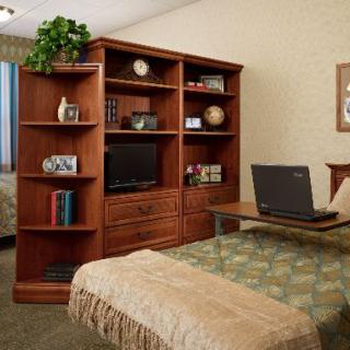A cozy bedroom with a wooden bookshelf and desk.