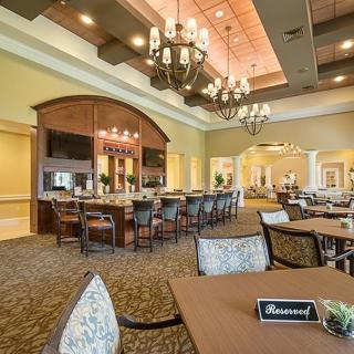 Elegant dining area with a bar and chandeliers, featuring a 'reserved' table.