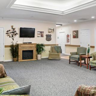 A spacious living room with comfortable seating, a television, and a fireplace.