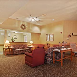 A cozy living room with sofas, armchairs, and lamps providing a warm ambiance.