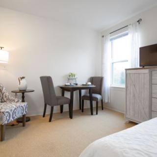 A cozy bedroom with a small dining area and elegant furnishings.
