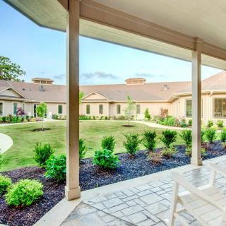 A view of a landscaped courtyard with garden space, seen from a covered patio.