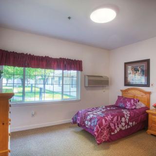 A cozy bedroom with a single bed and large window.