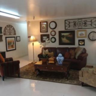 A cozy living room with art-adorned walls, comfortable seating, and warm lighting.