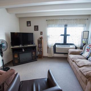 A cozy living room with a comfortable sofa, television, and window offering natural light.