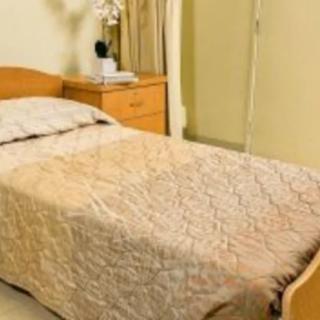 A cozy bedroom with a neatly made single bed and a nightstand.