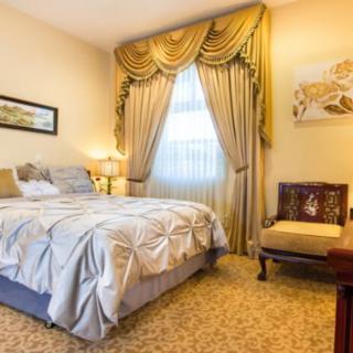 A beautifully decorated bedroom with luxurious curtains and traditional furnishings.