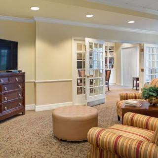 A cozy living room with a television, comfortable seating, and warm decor.