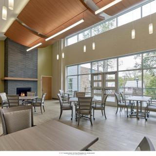 A modern dining area with large windows and a cozy fireplace.