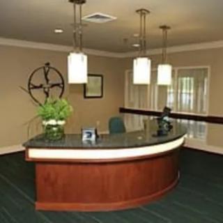 A modern and elegant office reception area with a curved desk and pendant lighting.