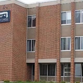 A brick commercial building with multiple windows and a visible sign.