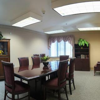 A spacious and elegantly furnished meeting room, equipped with a large conference table and comfortable seating.
