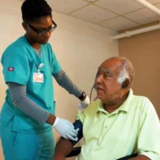 A nurse checks the blood pressure of an elderly patient in a healthcare setting.