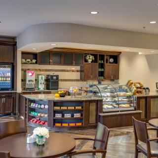 A modern cafe interior with a central counter and seating area.
