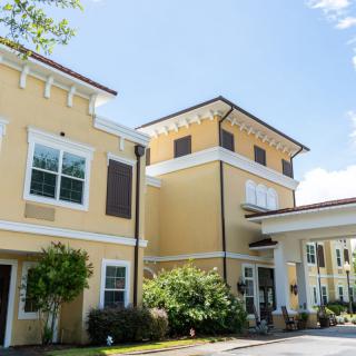 A sunny day view of a residential building with well-maintained landscaping.