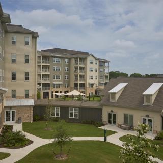 A view of a residential apartment complex with well-maintained gardens and pathways.