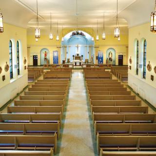 Interior view of a church with pews and altar.