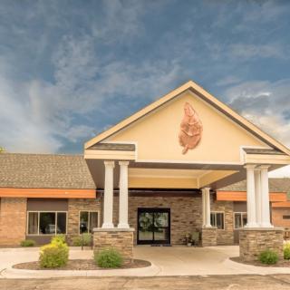 A building with a prominent entrance featuring columns and a decorative emblem above the door.