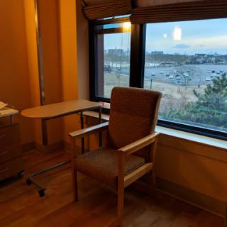 A cozy room featuring a comfortable chair by the window, offering a serene view of the ocean.