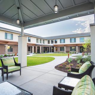 A modern courtyard featuring comfortable patio furniture and well-maintained landscaping.