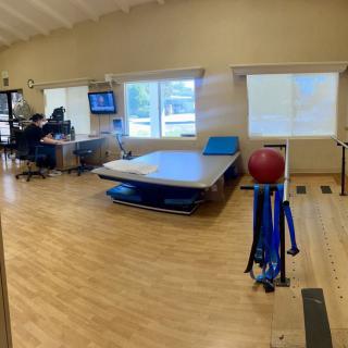 A rehabilitation center therapy room equipped with exercise tools and a bed.